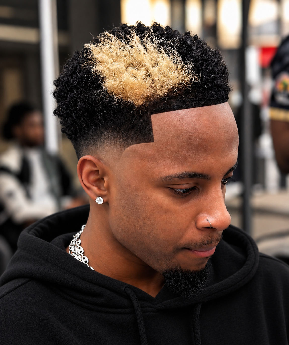 Dégradé précis sur cheveux bouclés avec touche blonde